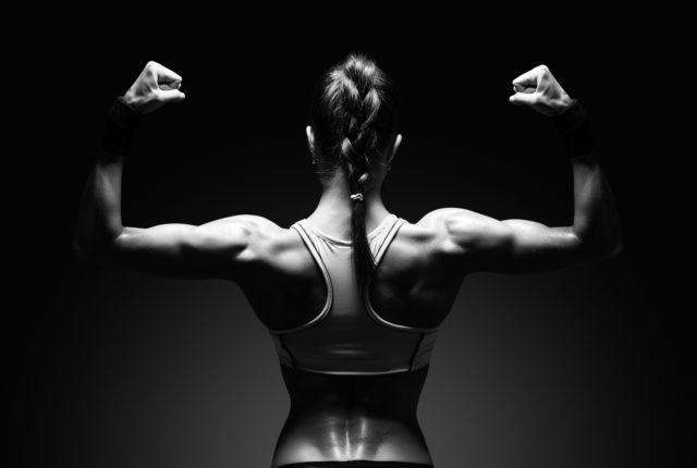 背中の筋肉を示す運動若い女性