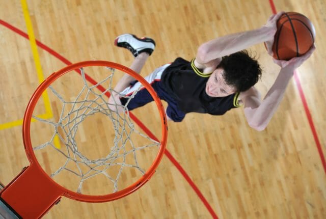 体育館でバスケットボールをプレーする男性