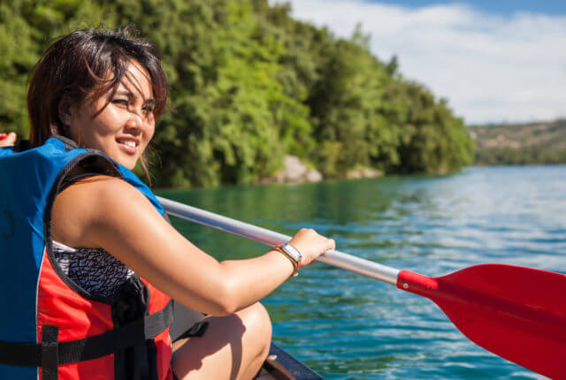 湖でカヌーを楽しむ若い女性
